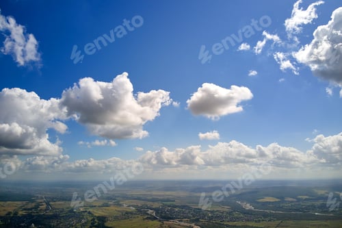 Preview: Aerial view from high altitude of earth covered with white puffy cumulus clouds on sunny day