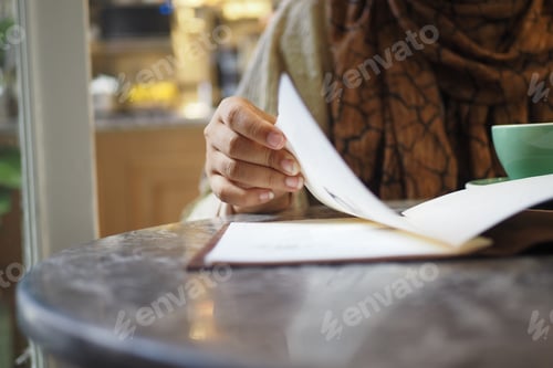 Preview: women hand reading a food menu at cafe.