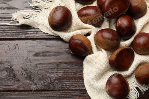 Preview: Sweet fresh edible chestnuts on wooden table, top view. Space for text