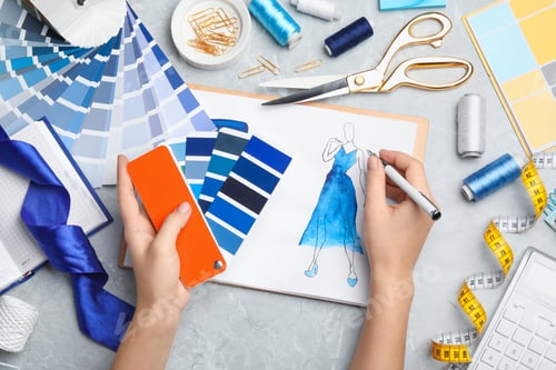 Preview: Fashion designer with color palette drawing dress at marble table, top view