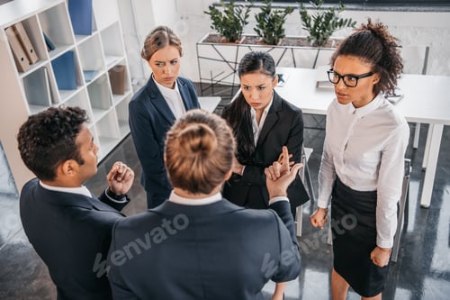 Preview: young coworkers in formalwear arguing at business meeting in office, business team meeting