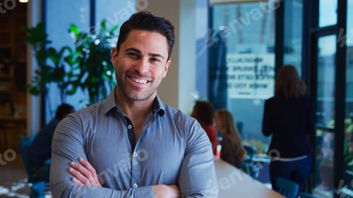 Preview: Portrait Of Mature Businessman Standing In Busy Modern Office With Colleagues In Background
