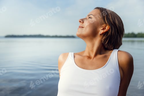 Preview: Close-up young beautiful tanned girl sunbathe on river, sea alone in the early morning. Natural