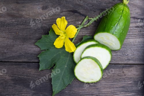 Preview: fruit and flower of the green luffa that is used for Asian cuisine