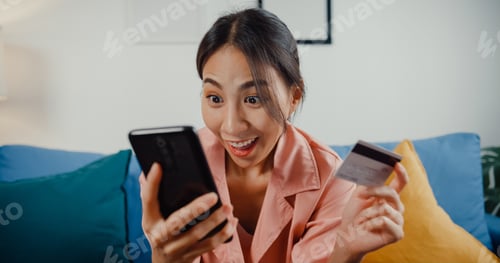 Preview: Asia lady use cellphone order online shopping product and paying bill with credit card.