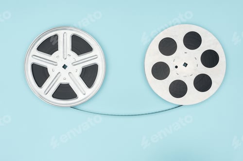 Preview: film reels with cinema tape between them isolated on blue