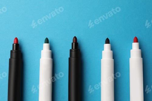Preview: Bright color markers on light blue background, flat lay. Space for text