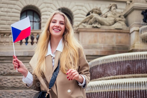 Preview: Young female tourist with czech flag wawing near fountain Wenceslas Square