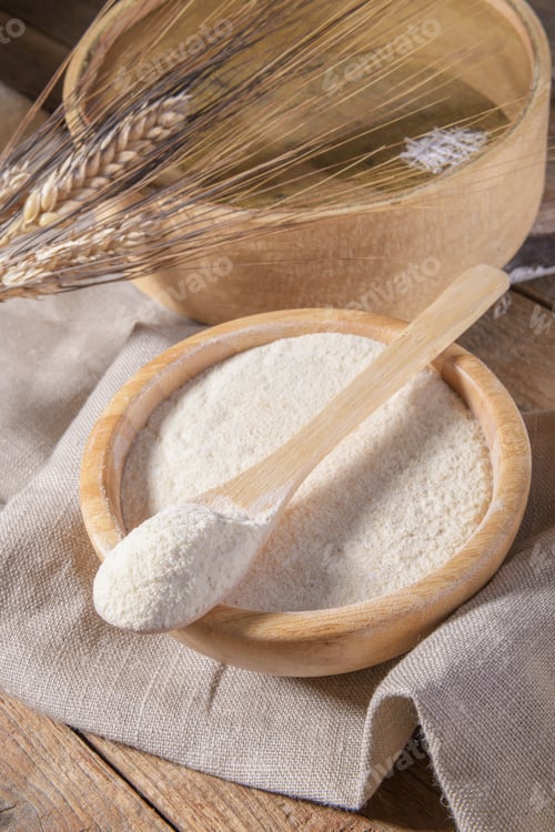 Preview: Whole wheat durum flour on a scooped spoon and in wooden bowl with spikelets