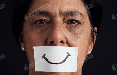 Preview: Portrait, smile or anxiety and a mature woman in studio on a dark background with a fake expression