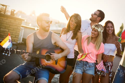 Preview: Group of happy friends having party on rooftop