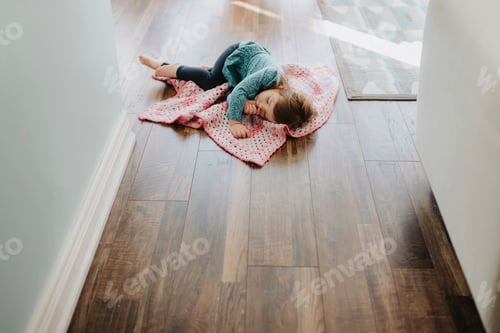 Preview: Female toddler asleep on security blanket in hallway