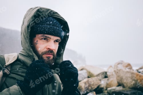Preview: Man trekking in winter by the sea.