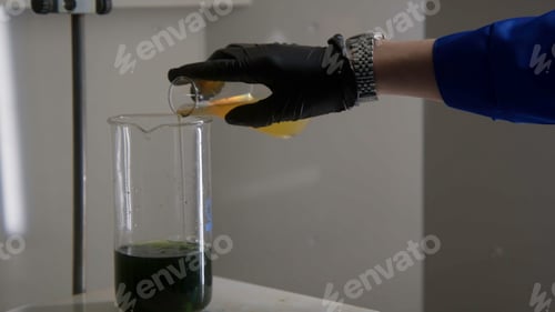 Preview: Close up of man pouring mixture in a beaker with solution inside. Stock footage. Equipment at the