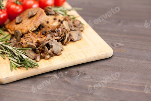 Preview: Tasty pork meat with grilled mushrooms next to oregano branch