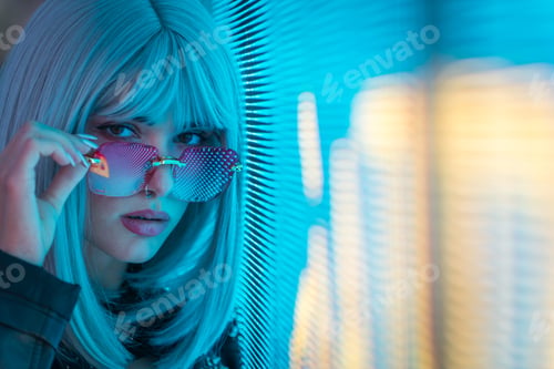 Preview: Image of a beautiful young woman posing against a led panel.