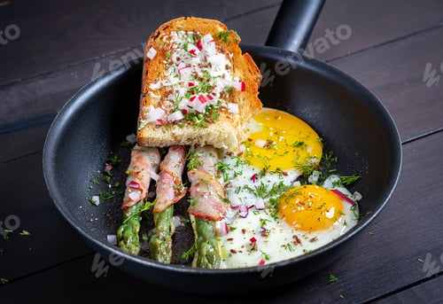 Preview: Keto breakfast. Fried eggs with asparagus in bacon and toast.
