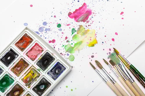 Preview: splashes of watercolor paint and painting supplies close up