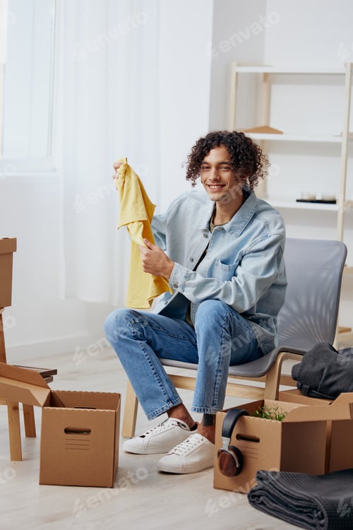 Preview: A young man sitting on a chair with boxes interior moving