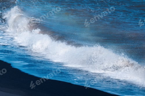 Preview: Blue ocean wave with splashing hitting on black sand beach in summer
