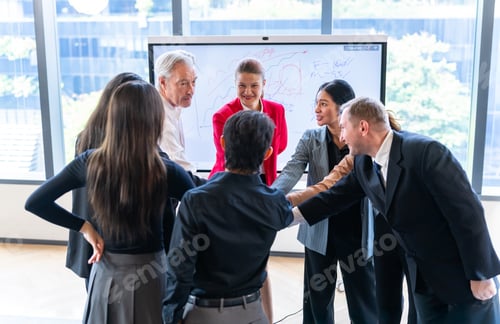 Preview: Diverse business team huddles together in a modern office, celebrating success and collaboration