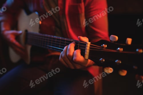 Preview: Mid-section of man playing guitar
