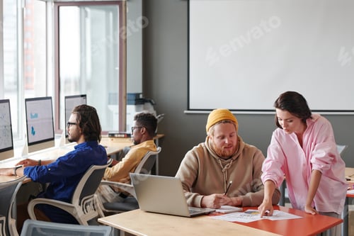 Preview: Colleagues discussing papers in modern office