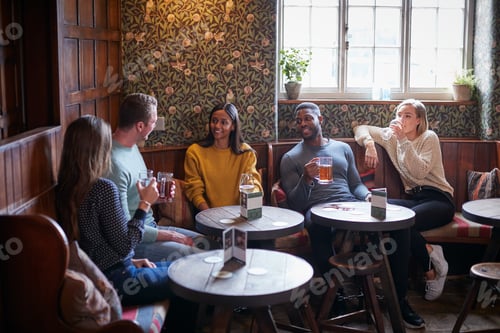 Preview: Group Of Friends Meeting For Lunchtime Drinks In Traditional English Pub