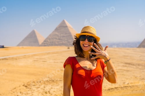 Preview: Portrait of a young tourist in red dress enjoying the pyramids of Giza