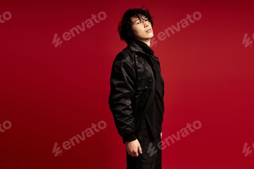 Preview: Studio serenity a young asian man poses in a fashionable outfit against red
