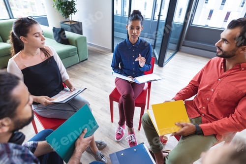 Preview: Diverse group of creative colleagues talking at casual meeting