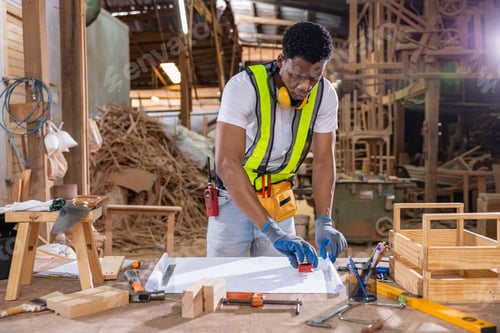 Preview: Focused carpenter sketching woodwork design on paper