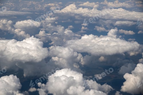 Preview: Aerial view from airplane window of white puffy clouds on bright sunny day