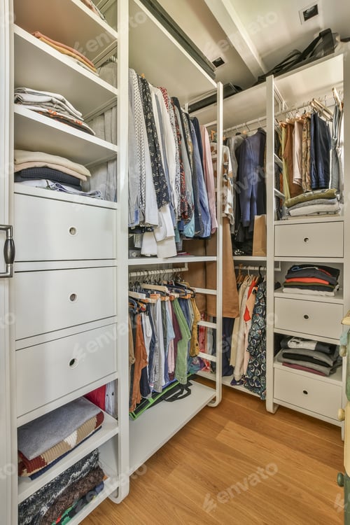 Preview: a walk in closet with white cabinets and drawers