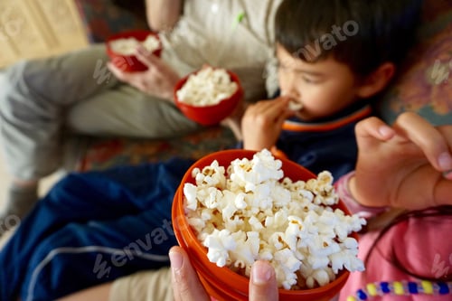 Preview: Child Enjoys Popcorn with Adult at Home