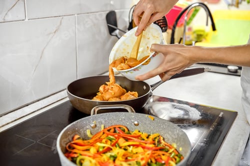 Preview: Cooking chicken breast and sauteing vegetables in a modern kitchen during meal preparation
