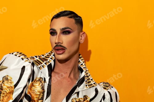 Preview: Portrait of beautiful drag queen model with yellow background