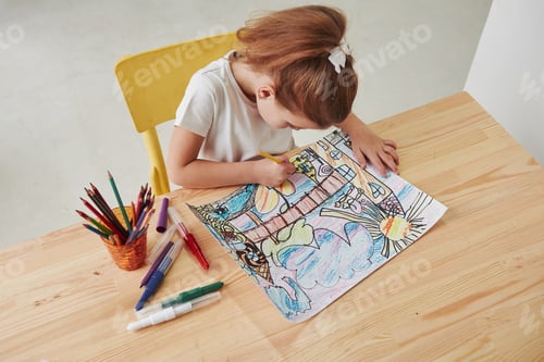 Preview: View from the top. Cute little girl in art school draws her first paintings by pencils and markers