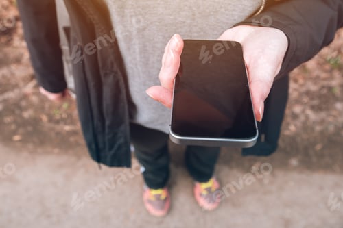 Preview: Close up of female hands using smartphone outdoors