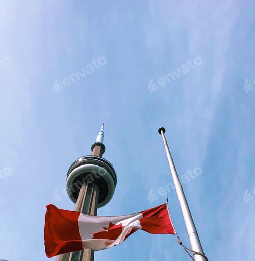 Preview: CN Tower in Toronto Canada with Canadian flag against blue sky