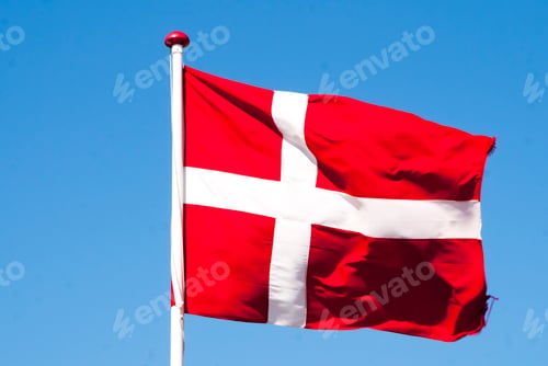 Preview: Flag of Denmark waving in the wind against a blue sky