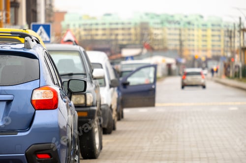 Preview: Cars parked in a row on a city street side.