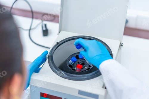 Preview: Scientist introducing blood samples in a centrifuge machine