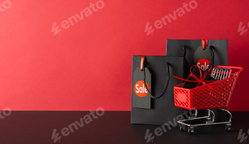 Preview: Black Friday haul: Side view of tiny shopping cart with gift box and black paper bags