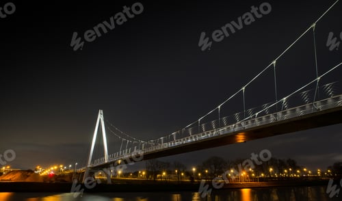 Preview: Low angle shot of a large bridge going over the water at night