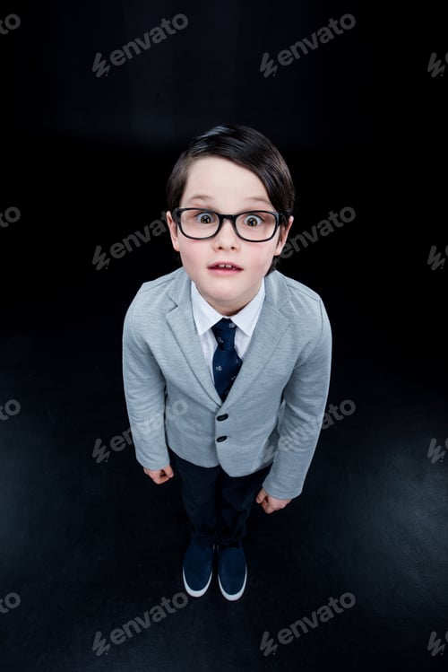 Preview: Shocked boy standing and looking at camera isolated on black