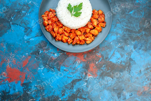 Preview: Half shot of delicious rice meal with green and tomato chicken on blue background