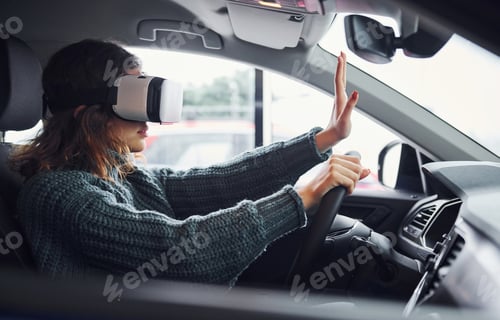 Preview: Side view of woman in virtual reality glasses that sitting inside of modern car
