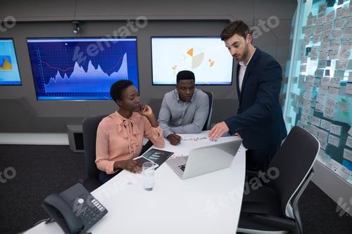 Preview: Male and female executives discussing over graph