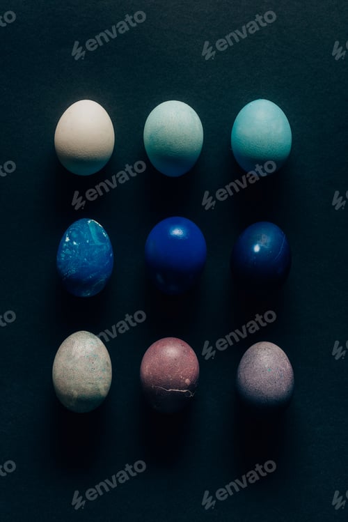 Preview: collection of nine colored painted easter eggs on dark surface